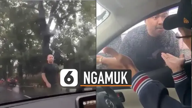 Pengendara tersebut memukul bagian depan mobil sambil mengacungkan jari.