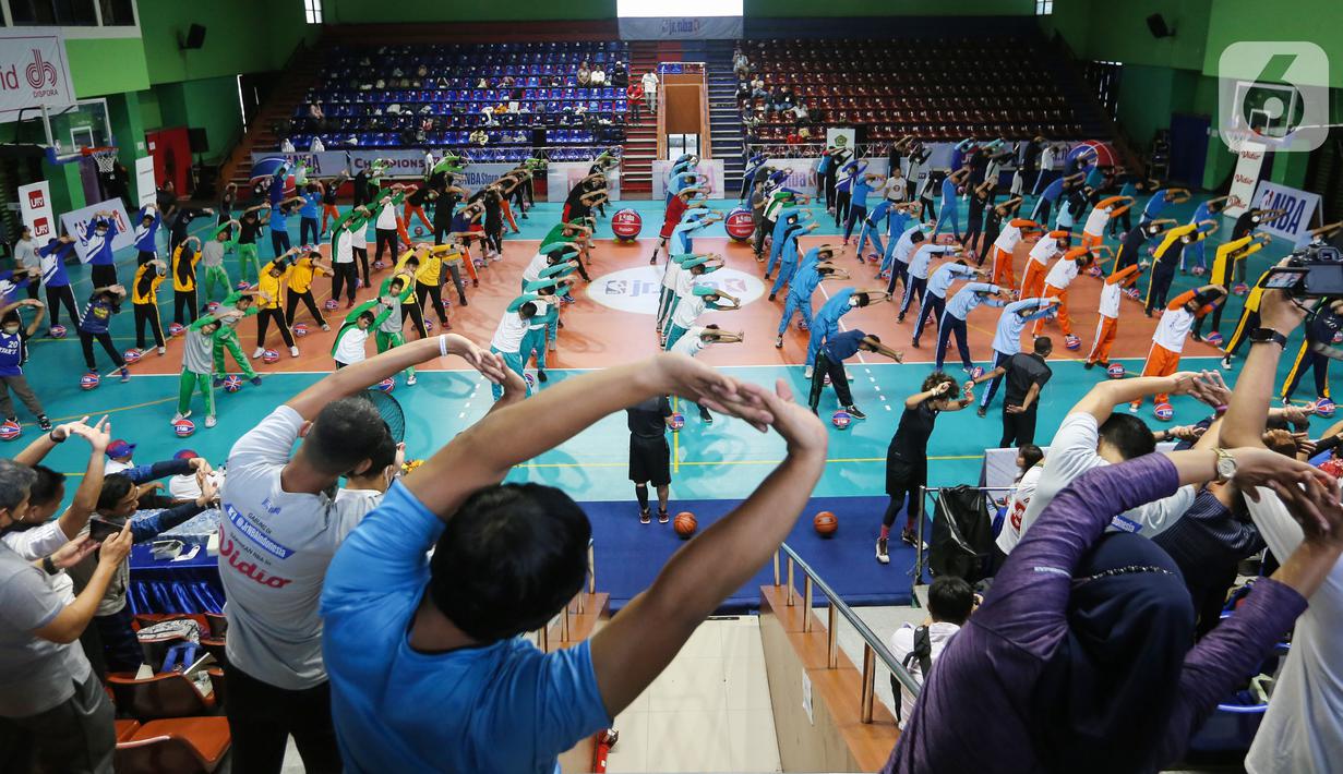 Siswa siswi Madrasah melakukan pemanasan sebelum mengikuti teknik dasar bola basket di GOR Bulungan Jakarta, Selasa (31/05/2022). Program Jr. NBA Coaches Academy diikuti oleh 450 guru dari Madrasah ditujukan bagi guru dan pelatih olahraga di Madrasah yang fokus pada keterampilan dan pelatihan basket, serta memberikan edukasi terkait kurikulum yang dapat diimplementasikan di sekolah. (Liputan6.com/Fery Pradolo)
