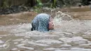 Seorang wanita terjatuh ke dalam lubang yang tak terlihat saat melintasi banjir di Jalan Taman Bukit Duri, Jakarta Selatan, Selasa (21/2). (Liputan6.com/Yoppy Renato)