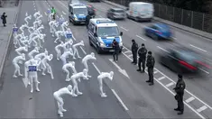 Aktivis dari Greenpeace mengenakan pakaian serba putih turun ke jalan melakukan aksi di Stuttgart, Jerman (19/2). Mereka melakukan aksi memprotes polusi yang diakibatkan oleh knalpot mobil diesel. (Sebastian Gollnow/dpa/AFP)