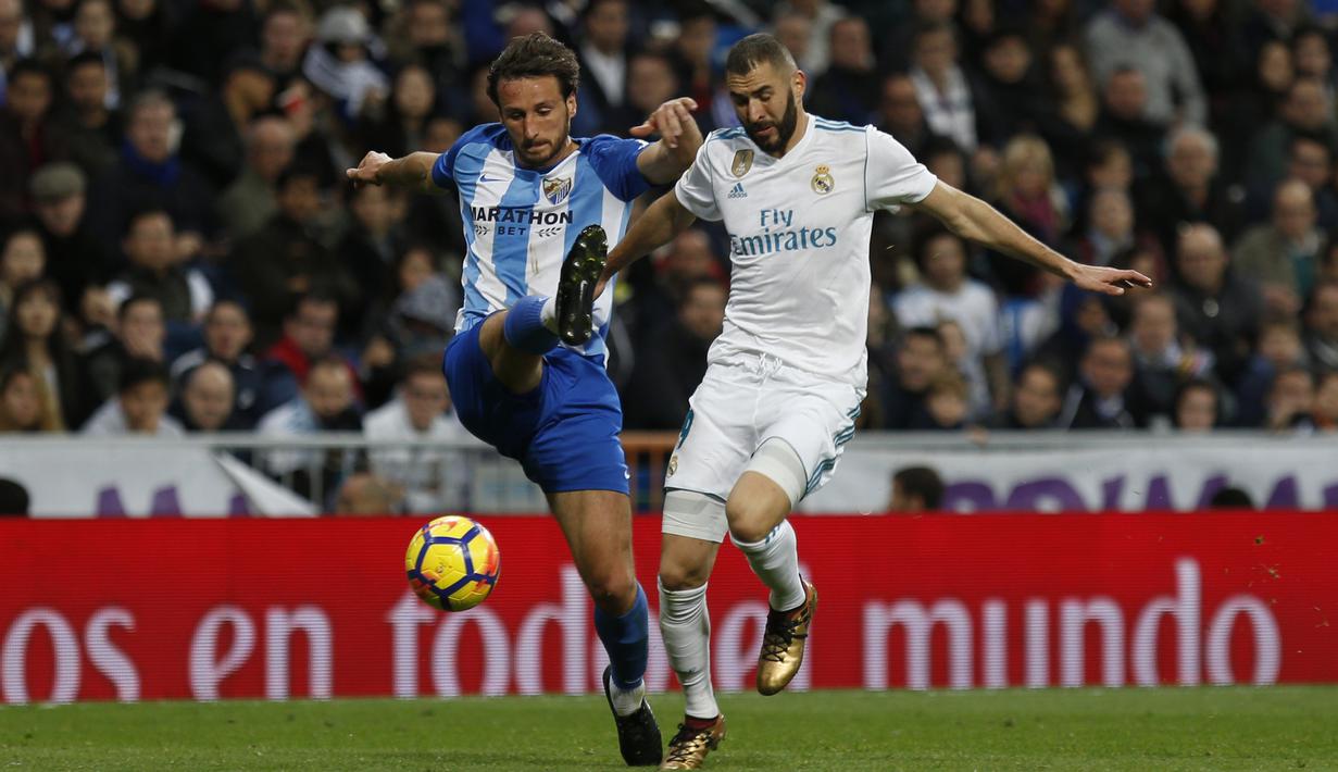 Pemain Real Madrid, Karim Benzema (kanan) berebut bola dengan pemain Malaga, Paul Baysse pada lanjutan La Liga Santander di Santiago Bernabeu stadium, Madrid, (25/11/2017). Madrid menang 3-2. (AP/Francisco Seco)
