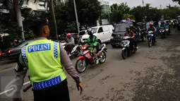 Seorang anggota polisi mengatur arus lalu lintas di Jalan Supomo, Jakarta, Senin (24/10). Indonesia Traffic Watch (ITW) menilai kemacetan di kota Jakarta saat ini sudah sampai pada tingkat 'gawat darurat'. (Liputan6.com/Helmi Fithriansyah)