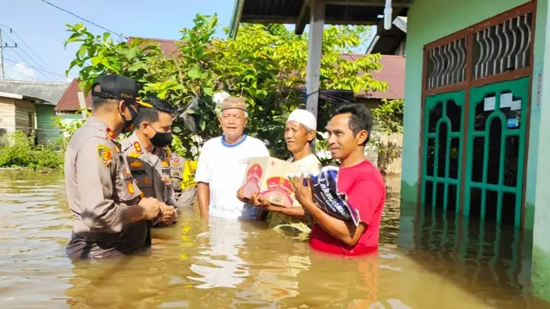 Kapolres Indragiri Hulu menyerahkan bantuan banjir ke rumah warga.