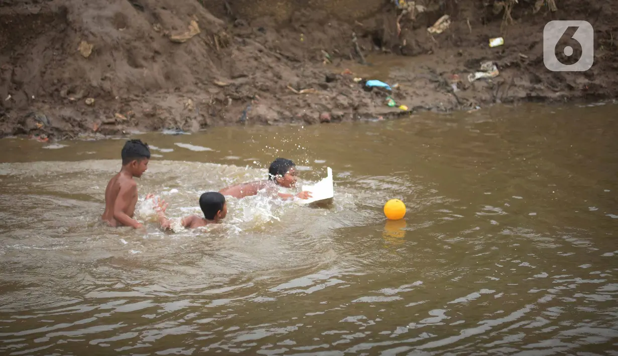 Sejumlah anak berenang di aliran Kali Ciliwung, Kampung Pulo, Jakarta, Jumat (2/12/2022).Minimnya lahan bermain menyebabkan anak-anak tersebut bermain tidak pada tempatnya, meskipun dapat membahayakan keselamatan. (merdeka.com/Imam Buhori)