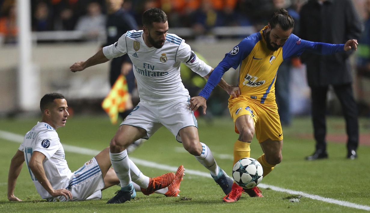 Pemain Real Madrid, Daniel Carvajal (tengah) beebut bola dengan pemain APOEL, Efstathios Aloneftis (kanan)  pada laga Liga Champions grup H di GSP stadium, Nicosia, (21/11/2017). Madrid menang 6-0. (AP/Petros Karadjias)