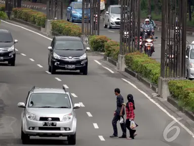 Pejalan kaki saat menyebrang dikawasan Kuningan, Jakarta, Selasa (13/1/2015). (Liputan6.com/Faizal Fanani)