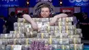 Joe McKeehen berpose diatas tumpukan uang yang ia menangkan dalama kejuaraan poker dunia di Las Vegas, Amerika Serikat, (10/11/2015). McKeehen memenangkan uang 107 Miliar rupiah dan gelang tanda kemenangan dalam kejuaraan ini. (REUTERS/Steve Marcus)