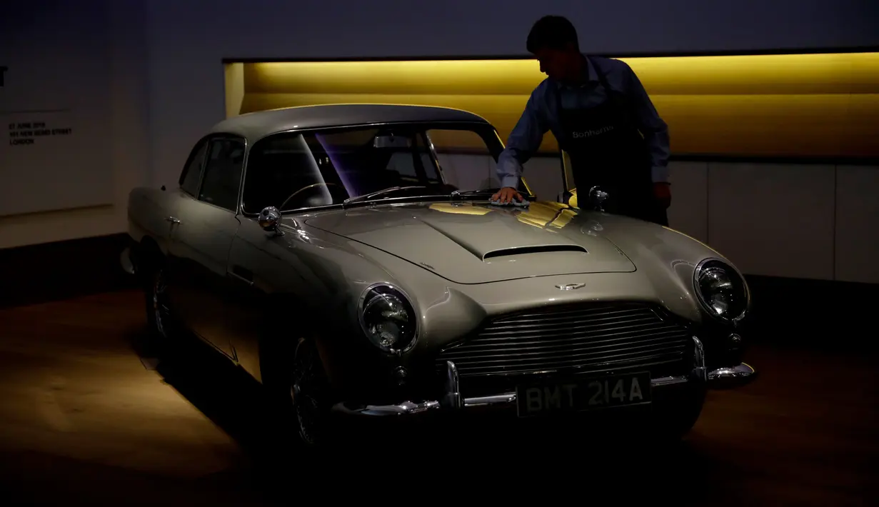 Staf berpose dengan Aston Martin DB5 yang digunakan dalam film James Bond GoldenEye tahun 1995 rumah lelang Bonham, London, Selasa (19/6). Di dunia, Aston Martin DB5 diproduksi sebanyak 1.059 unit di Inggris mulai tahun 1963 sampai 1965. (AP/Matt Dunham)