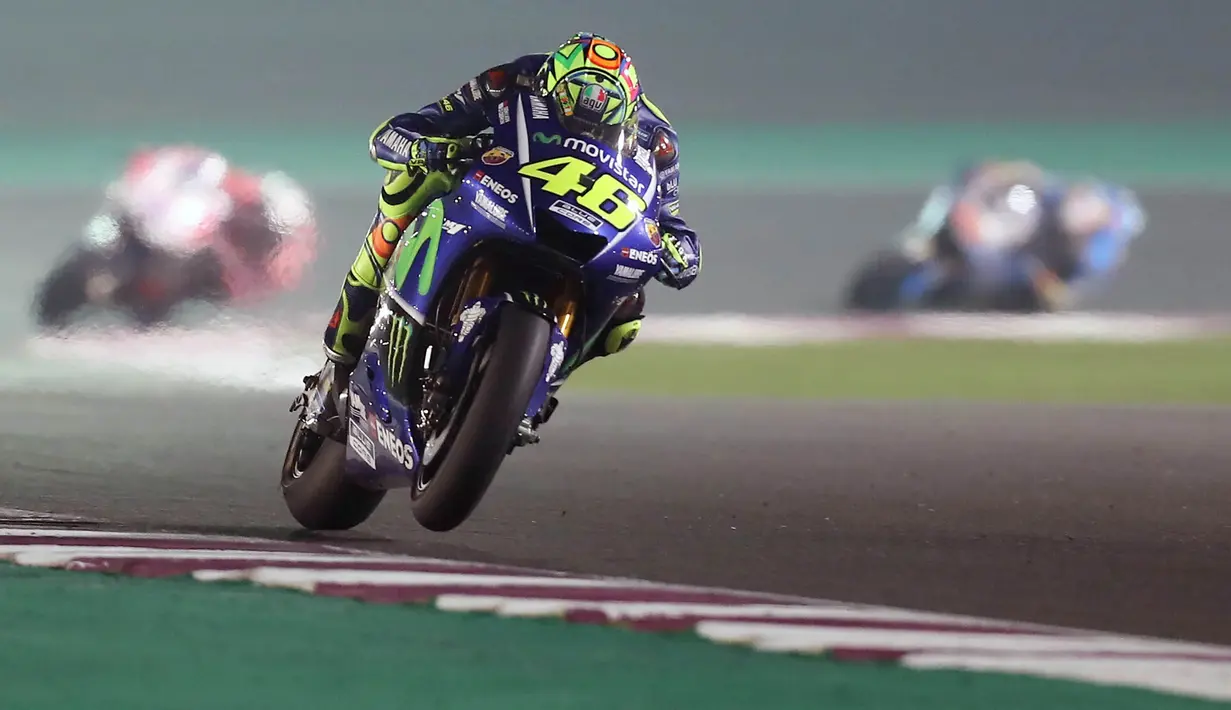 Pebalap Movistar Yamaha, Valentino Rossi, memacu motornya saat MotoGP Qatar. Meski memulai start dari posisi ke-10, namun The Doctor berhasil meraih podium dengan finish di urutan ketiga. (AFP/Karim Jaafar)