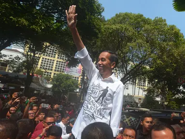 Presiden Joko Widodo menyapa pendukungnya usai mendaftarkan Capres-Cawapres ke Komisi Pemilihan Umum (KPU), Jakarta, Jumat (10/8). Jokowi dan Ma'ruf Amin resmi sebagai capres-cawapres untuk Pilpres 2019. (Merdeka.com/Imam Buhori)