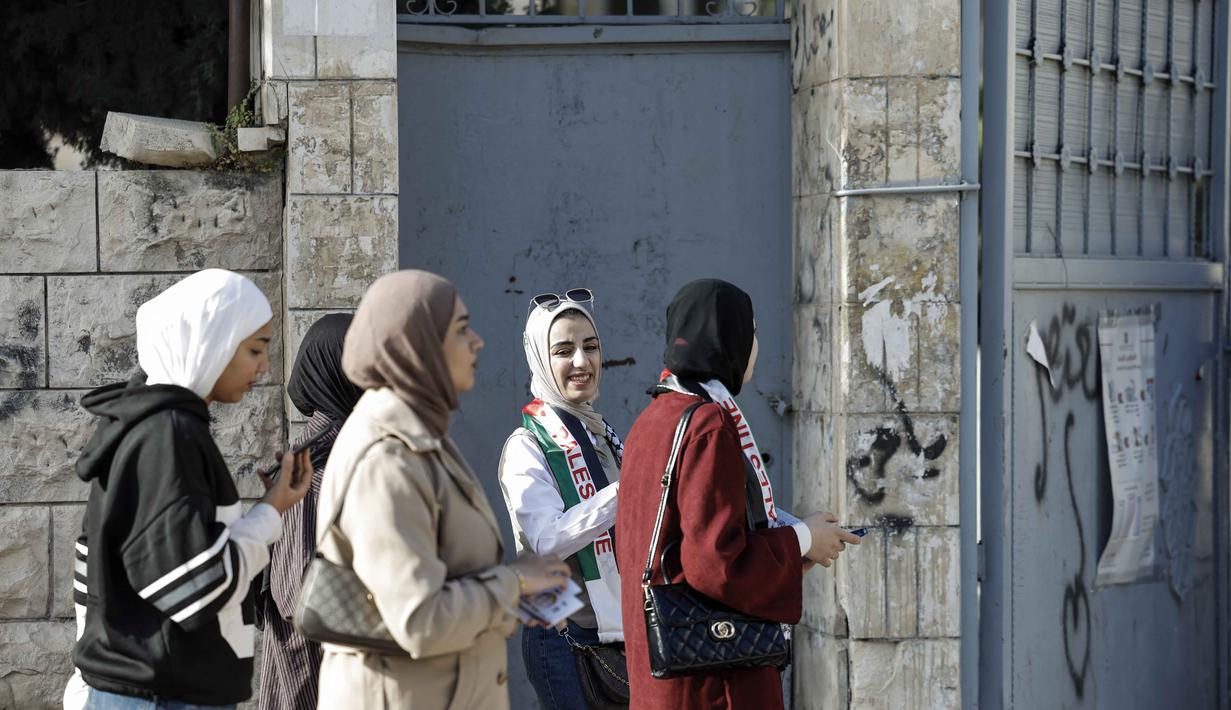 Pemilihan ini merupakan pemilu pertama di wilayah tersebut sejak konflik Israel-Hamas memanas pada Oktober 2023. Tampak dalam foto, perwakilan kandidat Palestina menunggu di luar Tempat Pemungutan Suara (TPS) selama pemilihan kota di Jenin, Tepi Barat yang diduduki Israel, pada Sabtu 25 April 2026. (Marco Longari/AFP)