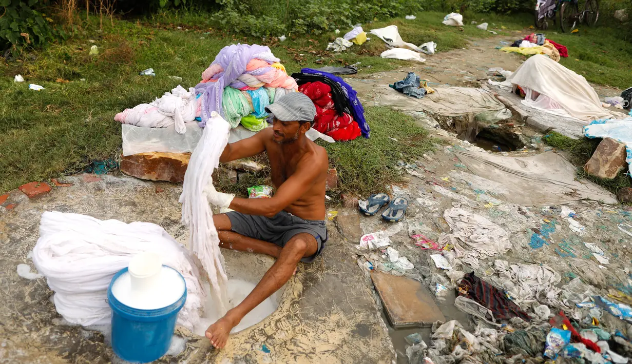 Dhobi, atau tukang cuci mencuci kain di tepi Sungai Gomti di Lucknow, 12 September 2020. Pekerjaan yang telah ada selama beberapa generasi  ini masih populer di India, meskipun ada teknologi modern dengan penghasilan setiap keluarga sekitar 100-200 dollar AS per bulan. (AP Photo/Rajesh Kumar Singh)