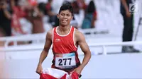 Atlet para-atletik Indonesia, Sapto Yogo Purnomo usai laga lari nomor 100 meter T37 pria yang  digelar di Stadion GBK, Jakarta, Selasa (9/10). Ini menjadi medali emas kedua Sapto di Asian Para Games 2018. (Liputan6.com/Helmi Fithriansyah)