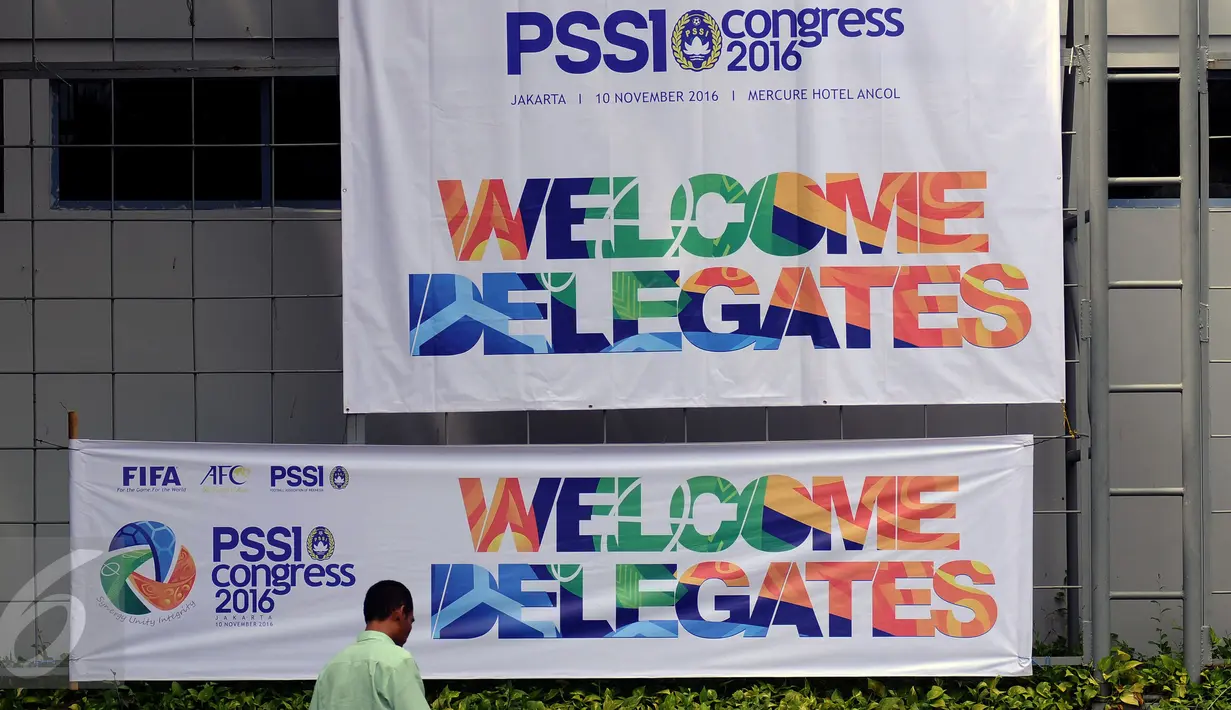 Pekerja melintas di depan baliho dan spanduk ucapan PSSI di depan Hotel Mercure Ancol Jakarta, Rabu (9/11). Kongres PSSI 2016 akan memilih Ketua dan Wakul Ketua serta anggota Komite Ekssekuitf. (Liputan6.com/Helmi Fithriansyah)