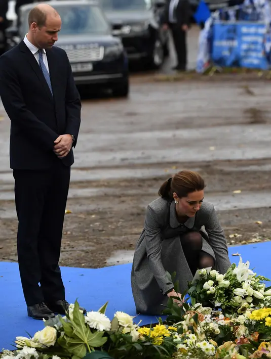 Pangeran William dan Kate Middleton meletakkan karangan bunga di depan markas Leicester City, Stadion King Power, Rabu (28/11). William dan Kate memberikan penghormatan kepada korban tewas dalam kecelakaan helikopter pada 27 Oktober 2018. (Paul ELLIS/AFP)