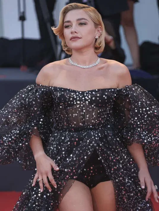 Florence Pugh berpose untuk fotografer setibanya di pemutaran perdana film 'Don't Worry Darling' selama Venice Film Festival 2022 ke-79 di Venesia, Italia (5/9/2022). Dia mengenakan bob pirang pendeknya yang longgar tapi tersapu ke belakang. (Photo by Joel C Ryan/Invision/AP)