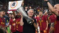 Pelatih kepala AS Roma, Jose Mourinho mengangkat trofi EUFA Conference League setelah berhasil membawa AS Roma mengalahkan Feyenoord dengan skor 1-0 pada laga final yang berlangsung di Stadion Arena Kombetare Tirana, Albania, pada Kamis (26/5/2022) dini hari WIB. Bagi Mourinho, trofi ini menjadi gelar juara Eropa-nya yang kelima. (AFP/Ozan Kose)