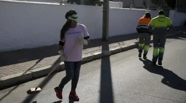 Seorang wanita pekerja seks (kiri) saat membersihkan jalanan kota madrid, Spanyol , Rabu  (14/10/2015).  Hal ini merupakan sikap protes terhadap pandangan masyrakat terhadap para PSK ini. . (REUTERS/Andrea Comas)