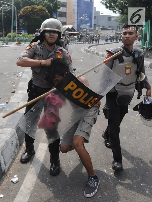 Anggota Sabhara Polri menangkap pengunjuk rasa saat bentrok  dengan massa aksi 22 Mei sebelum terjadi pembakaran bis milik Brimob di kawasan Tanah Abang,  Jakarta, Rabu (22/5/2019). (merdeka.com/Arie Basuki)