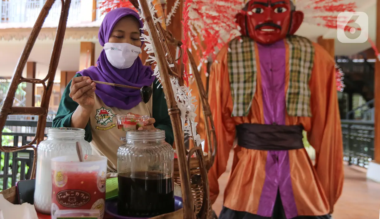 Pedagang membuat es selandang mayang di perkampungan Budaya Betawi Setu Babakan, Jakarta, Sabtu (8/8/2020). Guna memulihkan perekonomian selama pandemi pemerintah melalui Askrindo sebagai Penjamin Kredit Modal Kerja (KMK) membantu Kegiatan Pemulihan Ekonomi Nasional.  (Liputan6.com/Fery Pradolo)