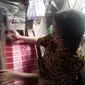 Salah satu pekerja perempuan di UMKM kain tenun Palembang (Liputan6.com / Nefri Inge)