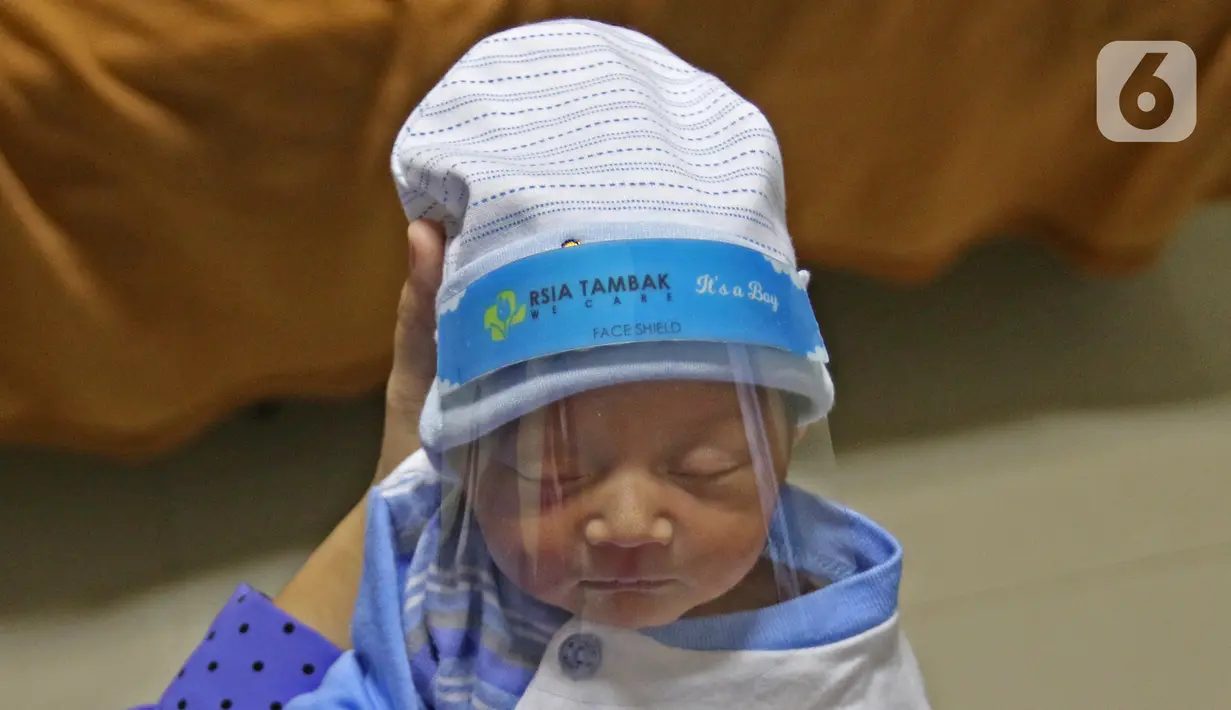 Seorang bayi memakai face shield atau pelindung wajah di Rumah Sakit Ibu dan Anak Tambak, Jakarta, Selasa (14/4/2020). RSIA Tambak sejak 12 April 2020 membuat kebijakan bayi yang baru lahir dipakaikan pelindung wajah untuk mencegah terpapar virus corona COVID-19. (Liputan6.com/Herman Zakharia)