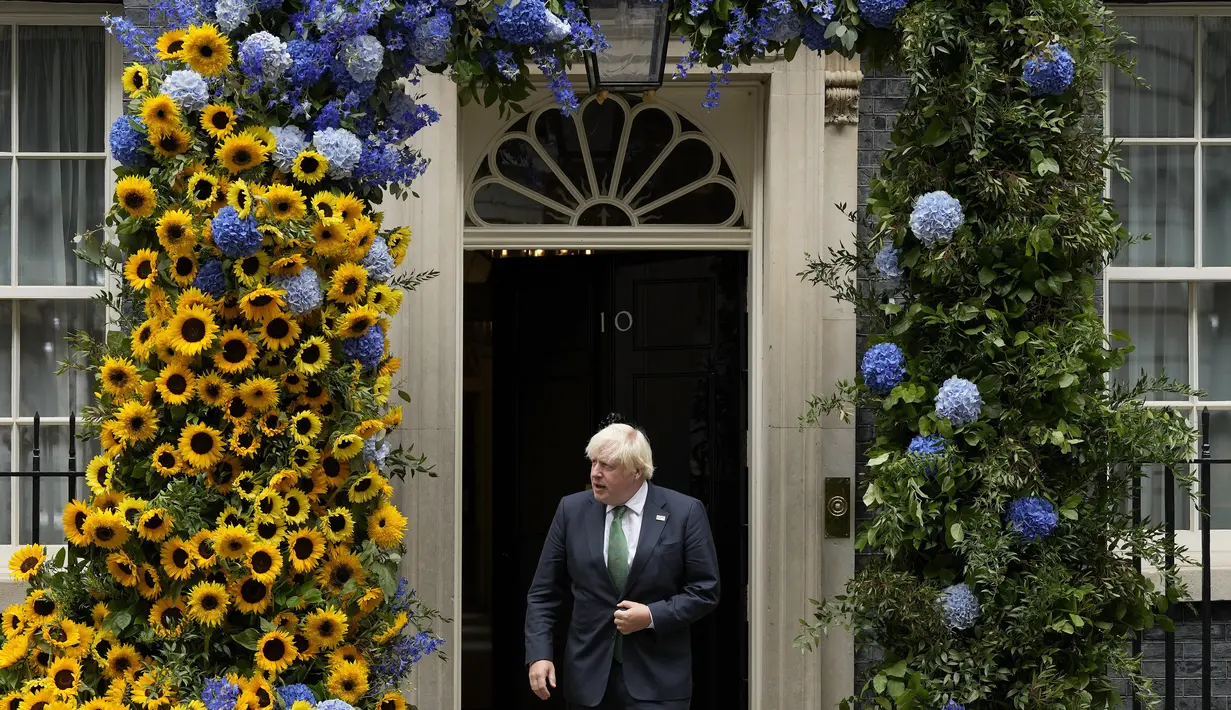 Perdana Menteri Inggris Boris Johnson meninggalkan 10 Downing Street untuk melihat dekorasi bunga matahari yang merupakan bunga nasional Ukraina, sehari menjelang Hari Kemerdekaan Ukraina, di London, Selasa (23/8/2022). Boris Johnson menunjukkan solidaritas Inggris dengan Ukraina dengan bunga matahari untuk memperingati hari kemerdekaan negara Eropa timur itu. (AP Photo/Frank Augstein)