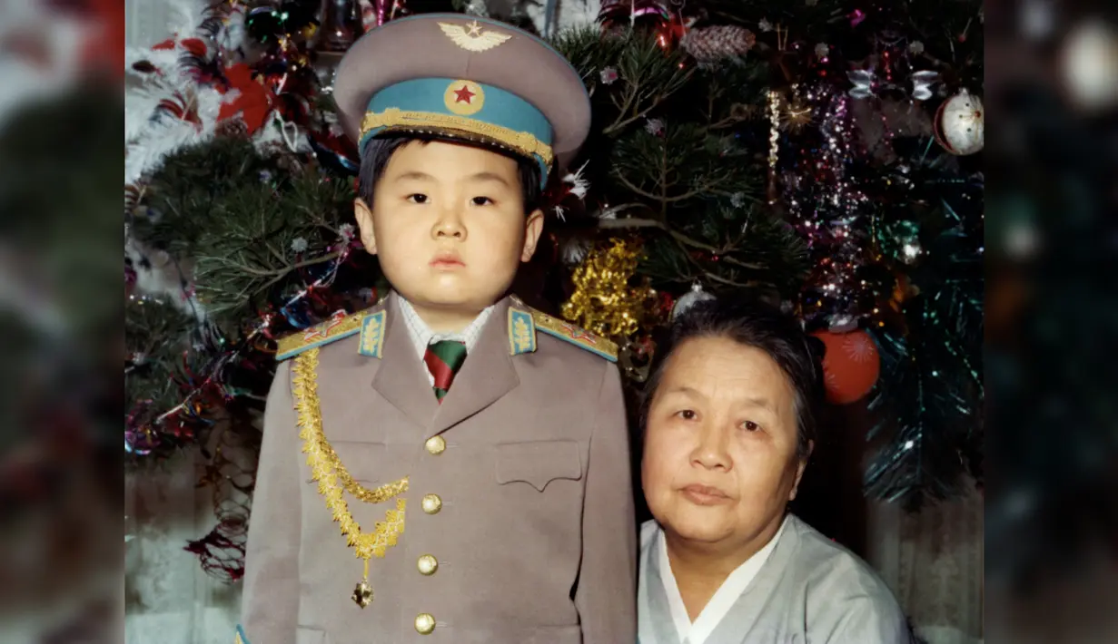 Kim Jong-Nam kecil mengenakan seragam tentara berpose dengan nenek dari pihak ibu pada Januari 1975. Kakak tiri Kim Jong-un, Kim Jong-nam, tewas dalam sebuah serangan di Bandara Internasional Kuala Lumpur pada 13 Februari 2017. (AFP PHOTO)