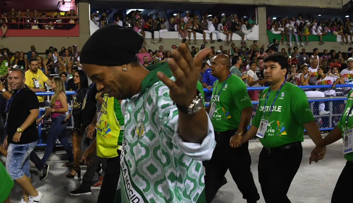 Mantan pemain Barcelona, Ronaldinho Gaucho saat tampil pada malam kedua Karnaval Samba di Sambadrome, Rio de Janeiro, Brasil (28/2). Karnaval Samba dimeriahkan oleh hampir seluruh sekolah samba di Brasil. (AFP Photo / Vanderlei Almeida)