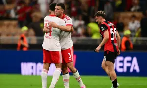 Bek Benfica asal Australia, Alessandro Circati, dan bek Portugal, Tomas Araujo, merayakan kemenangan timnya setelah pertandingan putaran pertama Liga Europa melawan AC Milan di Stadion San Siro, Milan, Kamis (17/9/2026) dini hari WIB. (Marco Bertorello / AFP)