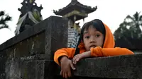 Seorang anak laki-laki ikut mengungsi setelah semakin meningkatnya aktivitas vulaknis Gunung Agung di Kecamatan Rendang, Bali, Kamis (21/9). Gunung suci umat Hindu Bali itu berstatus level tiga atau siaga sejak 18 September 2017. (SONNY TUMBELAKA/AFP)