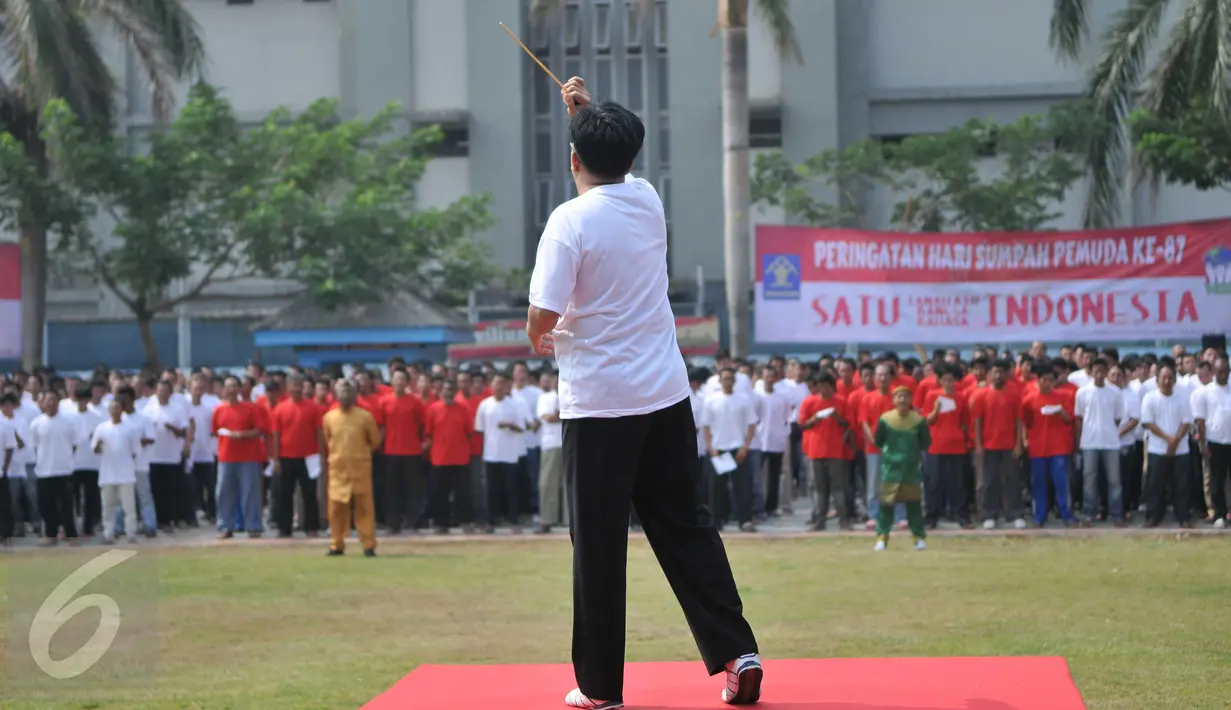 Seorang dirigen memimpin paduan suara dalam upacara peringatan 87 tahun Sumpah Pemuda di Lapas Narkotika Klas II A Cipinang, Jakarta, Rabu (28/10). Rencananya, upacara yang diikuti 2600 napi ini untuk memecahkan rekor MURI. (Liputan6.com/Gempur M Surya)