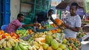 Seorang pelanggan memeriksa buah di pasar jalanan ketika keluarga berbelanja untuk liburan Muslim Idul Fitri, yang menandai akhir bulan puasa Ramadhan, di Mogadishu, Somalia, (19/5/2020). (AP Photo/Farah Abdi Warsameh)