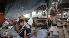 Seorang anak terlihat belajar meski dengan kondisi tempat tinggal yang memperihatinkan, Jakarta, Jumat (16/9). Sebelumnya, 50 bangunan liar di bawah kolong Tol Sedyatmo, Penjaringan kembali ditertibkan Pemkot Jakut. (Liputan6.com/Yoppy Renato)