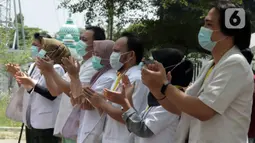 Tenaga kesehatan bertepuk tangan selama 56 detik pada peringatan Hari Kesehatan Nasional ke-56 di RSD Wisma Atlet, Jakarta, Kamis (12/11/2020). Aksi tersebut sebagai bentuk penghargaan kepada tenaga kesehatan yang berjuang menghadapi pandemi COVID-19. (Liputan6.com/Herman Zakharia)