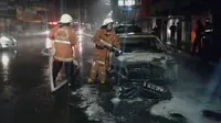 Petugas Pemadam Kebakaran memadamkan api yang membakar mobil di kawasan Gambir (Istimewa)