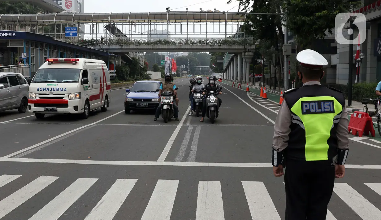 Polisi berdiri sikap sempurna di perempatan Bank Indonesia jalan MH Thamrin, Jakarta, Senin (17/8/2020). Dalam rangka HUT ke-75 tahun Kemerdekaan Indonesia, masyarakat menghentikan aktivitas selama tiga menit sebagai bentuk penghormatan detik-detik proklamasi. (Liputan6.com/Helmi Fithriansyah)