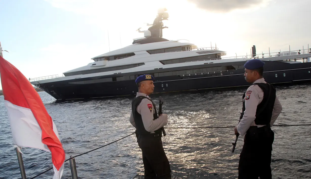 Petugas Polda Bali bersenjata laras panjang melakukan penjagaan saat kapal pesiar mewah (yacht) Equanimity terlihat berada di pelabuhan Benoa, Rabu (28/2). Equanimity juga disebut-sebut sebagai yacht terbesar ke-54 di dunia. (AP/Ambros Boli Berani)