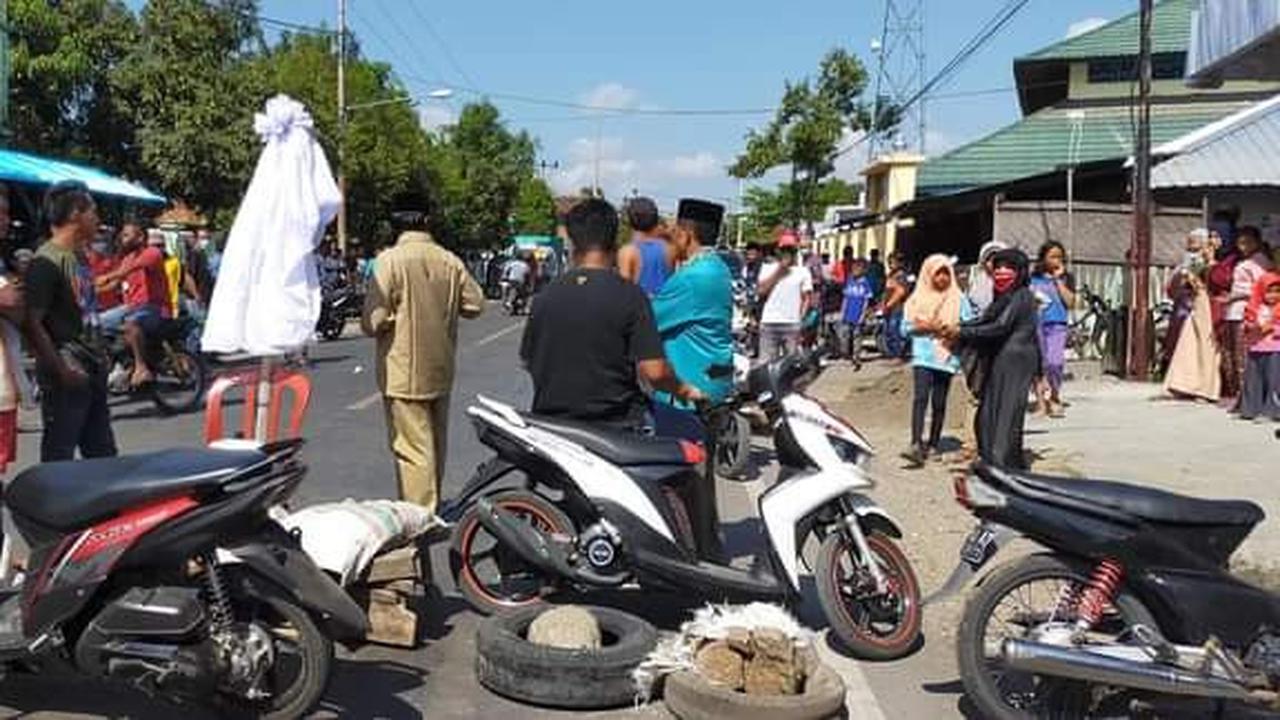 Warga memblokir jalan lintas Sumbawa-Bima usai gagal menjemput jenazah pasien Covid-19. (Foto: Liputan6.com/Miftahul Yani)