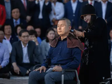 Pemimpin partai oposisi utama Korea Selatan, Hwang Kyo-ahn mencukur gundul kepalanya di luar Blue House, Seoul, Senin (16/9/2019). Aksi tersebut sebagai bentuk protes atas pengangkatan Cho Kuk sebagai Menteri Kehakiman di saat keluarganya tengah terjerat skandal hukum. (Ed JONES/AFP)