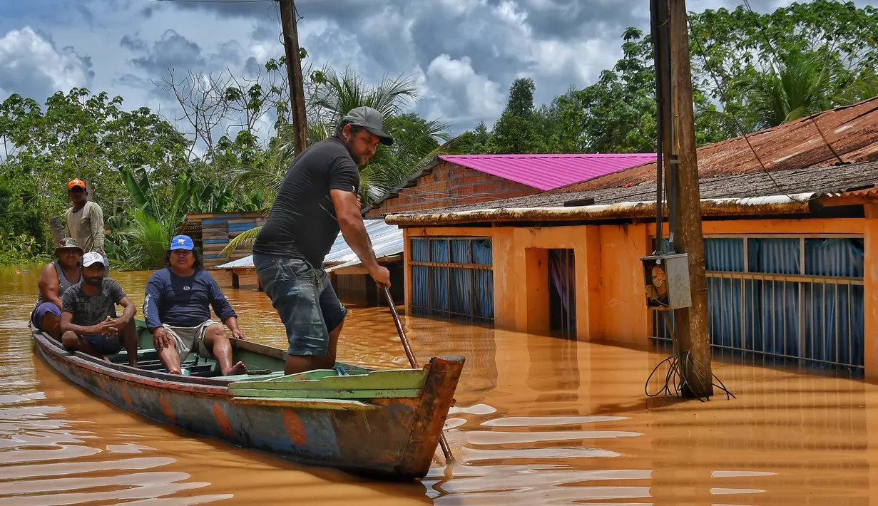 Orang-orang menaiki rakit di daerah yang terendam banjir setelah Sungai Acre meluap di Cobija, Bolivia, pada tanggal 29 Februari 2024. (STRINGER/AFP)