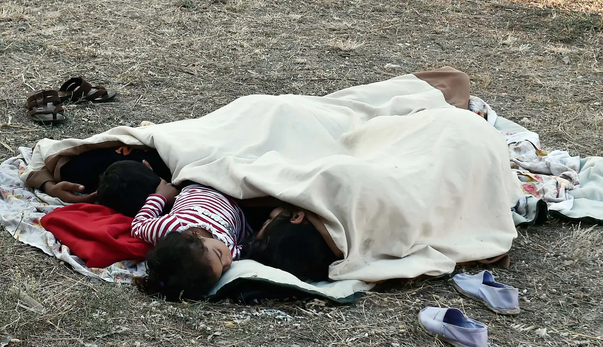 Seorang anak tidur di taman bermain setelah gempa 6,5 SR melanda Pulau Kos, Yunani, Sabtu (22/7). Gempa yang melukai 500 orang dan menewaskan dua orang membuat warga memilih tidur di luar rumah karena takut gempa susulan. (AFP Photo/Louissa Gouliamaki)