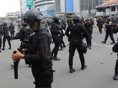 Personel Brimob mengusir massa usai terjadi pembakaran bus milik Brimob Polda Metro Jaya di kawasan Jalan Brigjend Katamso, Slipi, Jakarta, Rabu (22/5/2019). Dua bus milik Brimob Polda Metro Jaya dibakar massa di samping Jembatan Slipi Jaya. (merdeka.com/Arie Basuki)