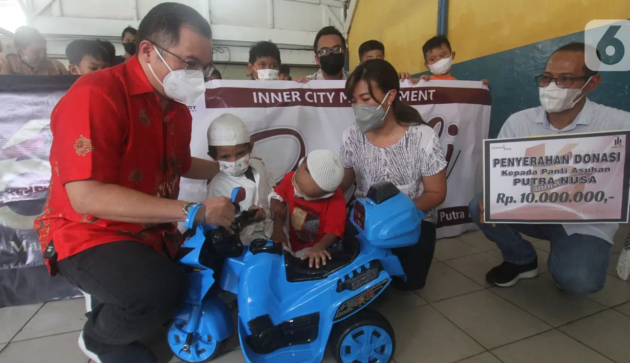 Ketua PPRS Apartemen Sudirman Park Rusli Usman (kiri) dan Ketua Panitia HUT ke-16 ICM Anggie Febrianti secara simbolis memberikan mainan kepada anak-anak panti asuhan di Yayasan Putra Nusa Jakarta, Jakarta (2/03/2022). (Liputan6.com/HO/ICM)