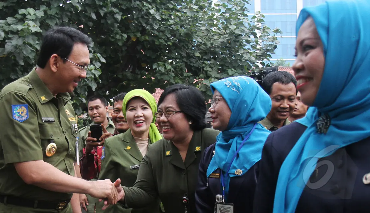 Gubernur DKI Basuki 'Ahok' Tjahaja Purnama (kiri) bersalaman dengan para guru saat meninjau hari pertama pelaksanaan ujian nasional (UN) di SMKN 27 Jakarta, Senin (13/4/2015). (Liputan6.com/Herman Zakharia)