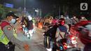 Polisi mengatur pemudik motor yang melintas di posko penyekatan mudik di Kedungwaringin, Kabupaten Bekasi, Jawa Barat, Selasa (11/5/2021) dini hari. Diskresi terhadap pemudik motor dilakukan sebagai langkah pencegahan mengurangi kerumunan. (Liputan6.com/Herman Zakharia)