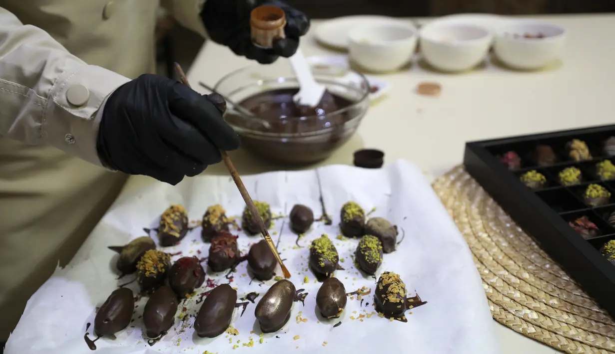 Wanita Palestina bernama Sojood Silwadi membuat kurma berlapis cokelat di rumahnya di Kota Nablus, Tepi Barat, 15 November 2020. Silwadi (26) merintis proyeknya setahun lalu. (Xinhua/Ayman Nobani)