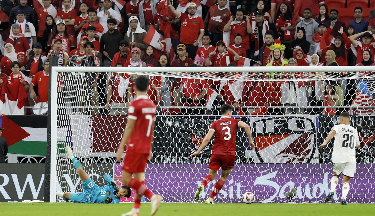 Suporter Timnas Indonesia tampak histeris saat melihat gol pemain Irak, Osama Rashid, ke gawang Indonesia pada laga perdana Grup D Piala Asia 2023 di Ahmed bin Ali Stadium, Senin (15/01/2024). (AFP/Karim Jaafar)