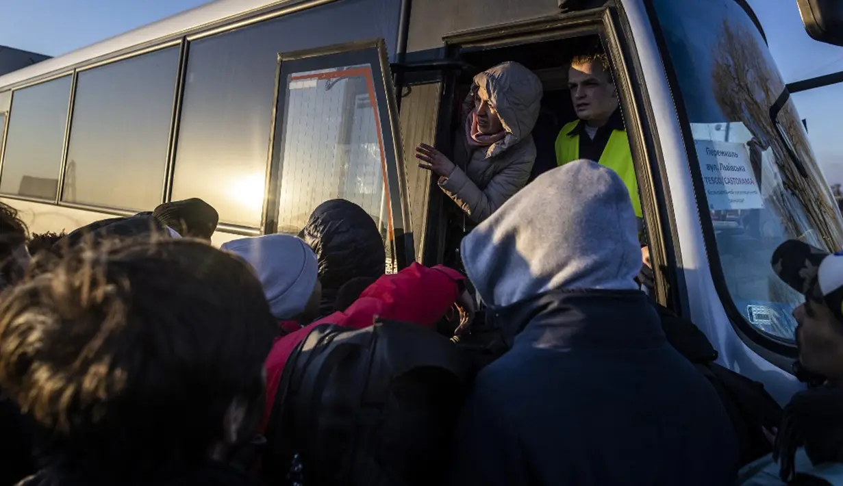 Pengungsi dari Ukraina berkumpul untuk naik bus dari perbatasan di Medyka ke Przemysl, Polandia timur, 28 Februari 2022. Lebih dari setengah juta orang telah meninggalkan Ukraina sejak invasi Rusia dengan lebih dari setengahnya melarikan diri ke Polandia. (Wojtek RADWANSKI/AFP)