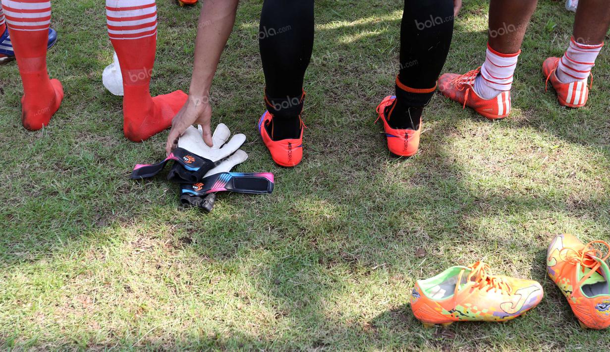 Sarung tangan dan sepatu pemain Persija berwarna oranye usai latihan di Lapangan Villa 2000, Pamulang, Tangerang Selatan, Senin (25/4/2016). (Bola.com/Nicklas Hanoatubun)